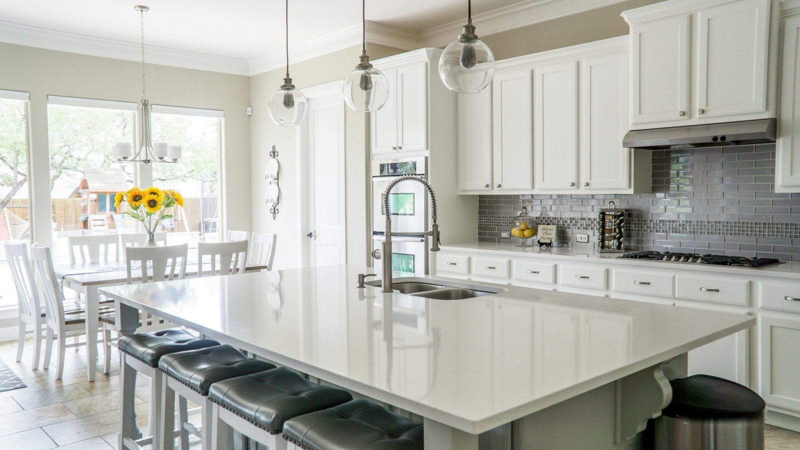 Spacious modern kitchen with white cabinets and island in natural light.